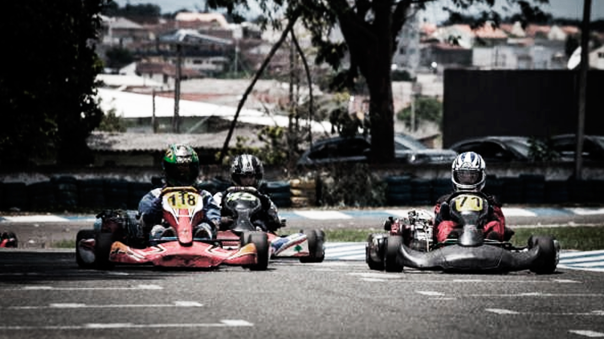 Três pilotos correndo em no kartódromo outdoor da empresa Kartódromo São José dos Pinhais