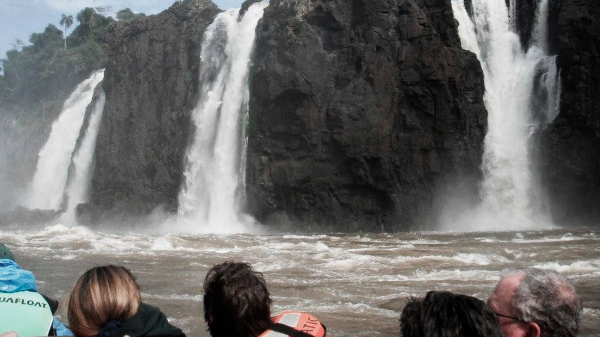 Grupo de pessoas praticando rafting no rio iguaçu, em Foz do Iguaçu. Em frente as quedas d'água
