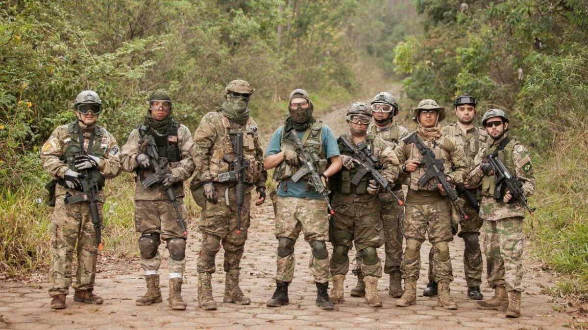 Na imagem, 9 jogadores de airsoft, vestindo os equipamentos para a prática pousam para a foto.